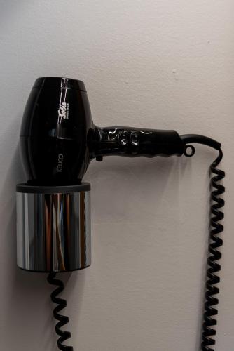 a black hair dryer hanging on a wall at Apartments Adlerhorst Top 1 Zell am See including Zell am See-Kaprun Summercard in Zell am See
