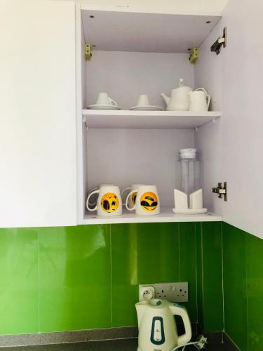 a cupboard with halloween bowls and mugs in it at Sacha Tourist Residence 2 in Mahébourg
