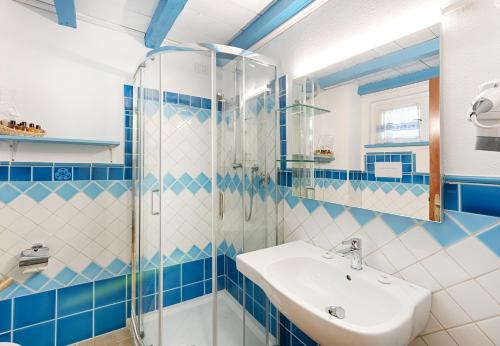 niebiesko-biała łazienka z umywalką i prysznicem w obiekcie Hotel Colonna San Marco w mieście Porto Rotondo