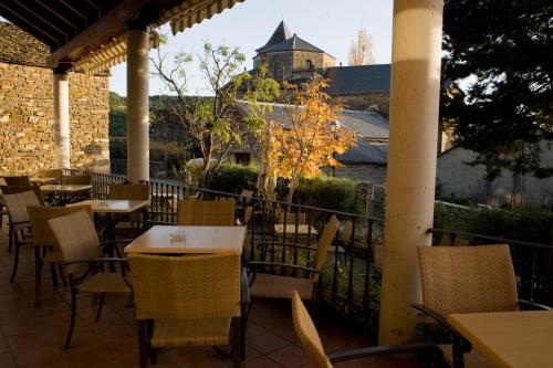 a patio with tables and chairs and a castle in the background at Valle de Aísa in Aísa