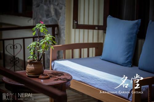 una camera da letto con un letto e una pianta in vaso su un tavolo di Mingtang Boutique Cottage 名堂花园度假屋 a Pokhara