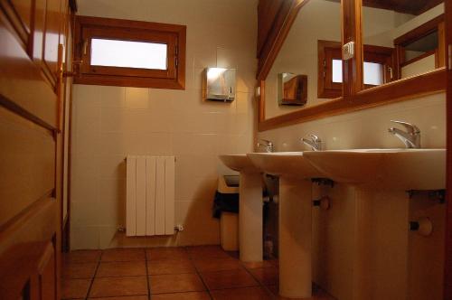 ein Bad mit 2 Waschbecken und einem Fenster in der Unterkunft Valle de Aísa in Aísa