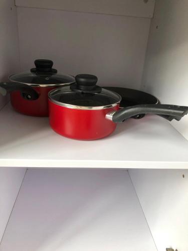 two pots and pans sitting on top of a shelf at Sacha Tourist Residence 2 in Mahébourg