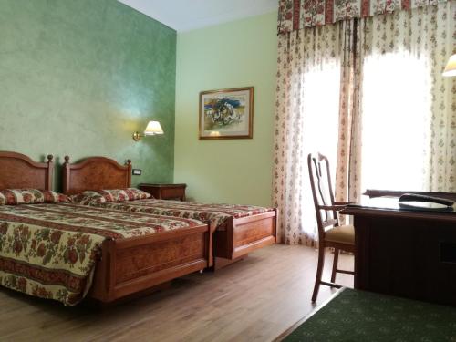 a bedroom with a bed and a table and a desk at FILIPPONE HOTEL&RISTORANTE in Gioia dei Marsi
