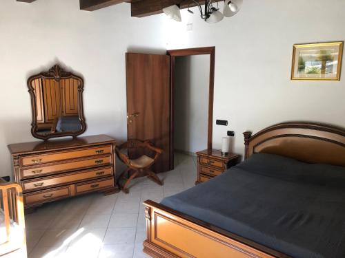 a bedroom with a bed and a dresser and a mirror at Casa Vacanze Bello in Pietraroia