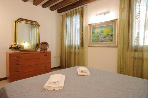 a bedroom with a bed with a mirror and a dresser at APPARTAMENTO PARADISO CA' GIULIA in Venice