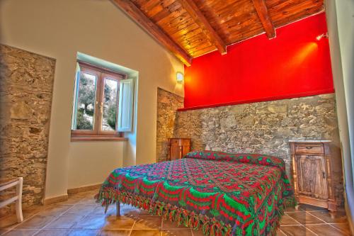 sypialnia z łóżkiem w kamiennej ścianie w obiekcie Kasale B&B Country House w mieście Torretta