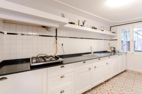 Una cocina con gabinetes blancos y un fregadero. en Büyük Konak İzmir, en Izmir