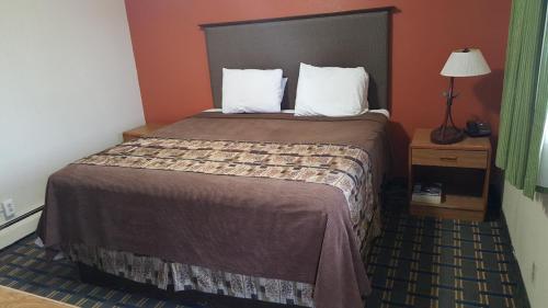 a hotel room with a large bed in a room at Budget Inn Tonawanda in Tonawanda