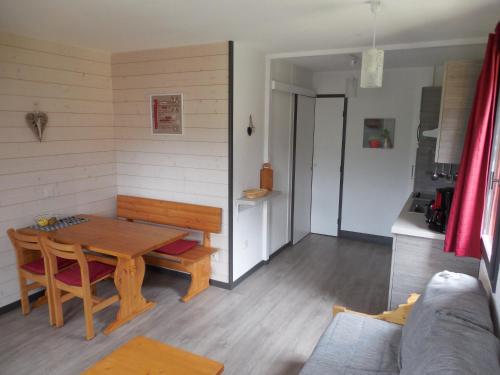 Il comprend un salon avec une table en bois et une cuisine. dans l'établissement Belle Plagne 1 Appart 6 pers du Dimanche au Dimanche Ski au pieds, à La Plagne