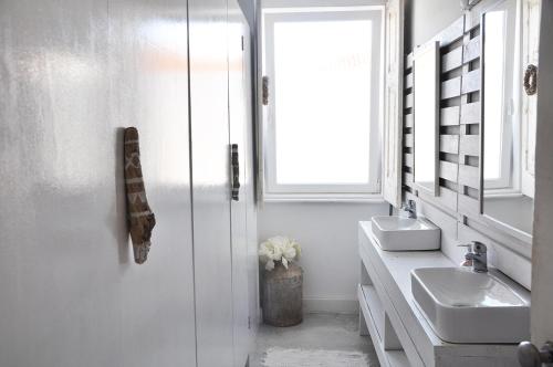 a white bathroom with two sinks and a window at Aloha Beach House H in Cascais