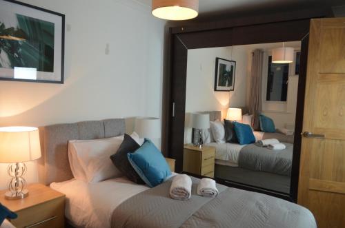 a bedroom with two beds with blue and white pillows at Mundy House in Swindon