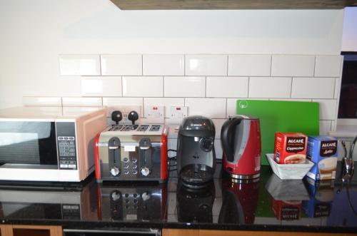 a kitchen counter with a microwave and appliances on it at Mundy House in Swindon