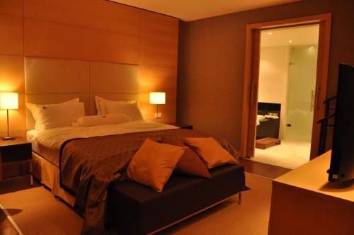 a bedroom with a bed and a couch with two lamps at Hotel Grand Swiss in Erbil
