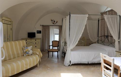 a bedroom with a bed and a couch at Palazzo Altavilla in Ostuni