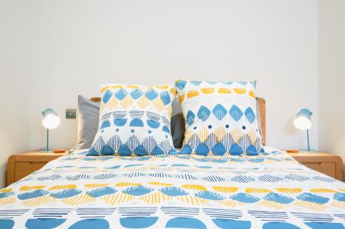 a bed with blue and white sheets and two pillows at Finest Retreats - Luxury Holiday Let in Porthleven, Sleeping 2 in Porthleven