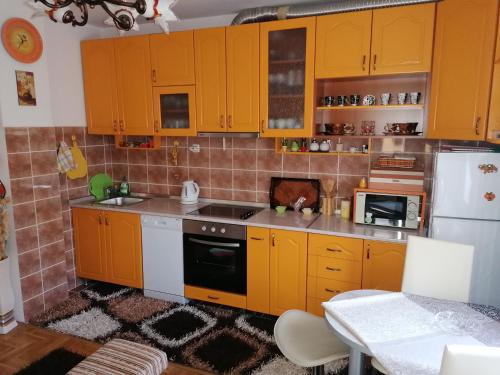 a kitchen with yellow cabinets and a white refrigerator at Apartman Nena in Nova Varoš
