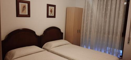 a bedroom with two beds and a window at Pensión CASA LEÓN in Santoña