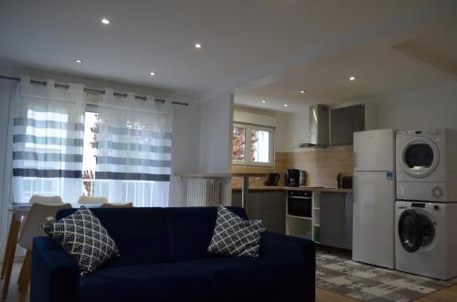 un salon avec un canapé bleu et une cuisine dans l'établissement La Crochardière centre ville Le Mans, au Mans