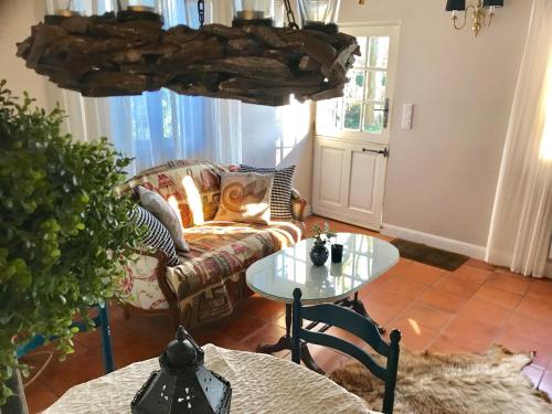 un salon avec un canapé et une table dans l'établissement Charmante Petite Maison dans le Jardin, à Letteguives