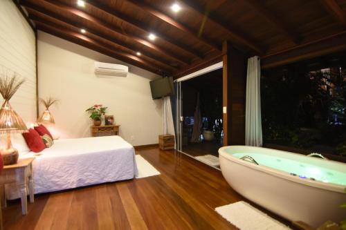 a bedroom with a bed and a bath tub at Pousada Riacho Dos Cambucas in Abraão