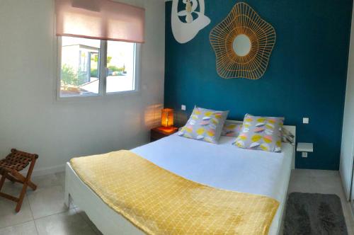 - une chambre dotée d'un lit avec un mur bleu dans l'établissement Villa Pignada, à Lanton