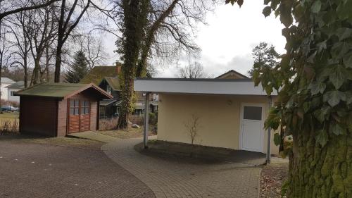 een klein huis met een garage en een boom bij FERUN in Zinnowitz