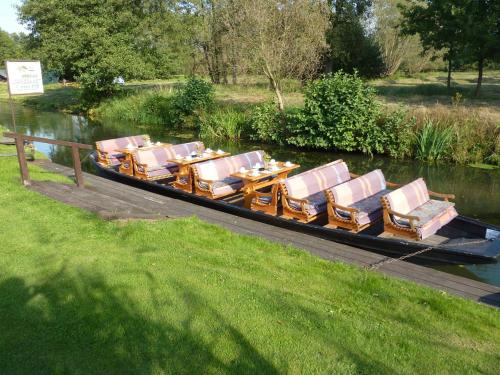 a boat with chairs and a table on the water at Spreewald Pension Spreeaue in Burg
