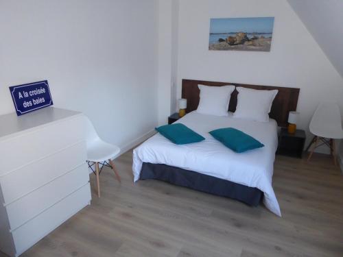 une chambre avec un lit blanc avec deux oreillers dans l'établissement Villa à la croisée des baies, à Tréméoc
