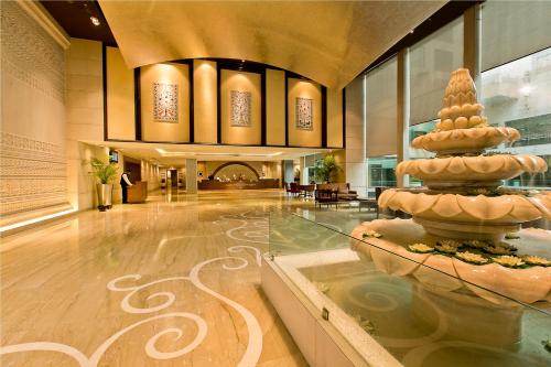 a lobby with a fountain in the middle of a room at The Lalit Jaipur in Jaipur