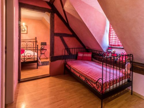 ein Schlafzimmer mit einem Bett im Dachgeschoss in der Unterkunft Chambres d'hôtes au Freidbarry in Schillersdorf