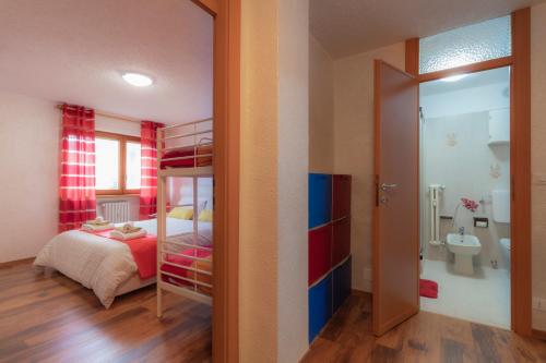 a bedroom with a bunk bed and a bathroom at SauzeMonAmour in Sauze dʼOulx