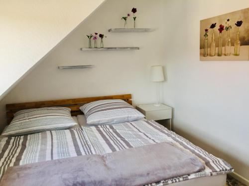 a bedroom with a bed with two pillows and shelves at Ferienwohnung Molter in Oberthal