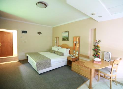 a bedroom with a bed and a desk and a table at Royal Court Hotel in Ramallah