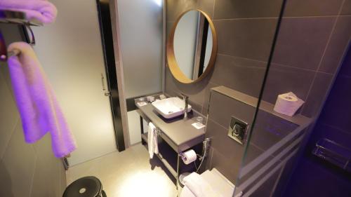 a small bathroom with a sink and a mirror at Royal Court Hotel in Ramallah