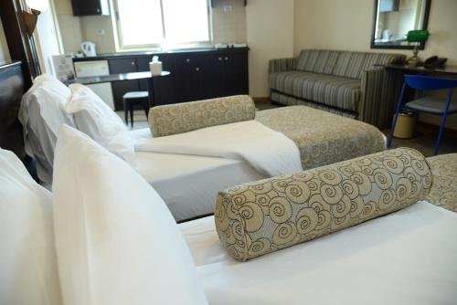 a hotel room with two beds and a couch at Royal Court Hotel in Ramallah