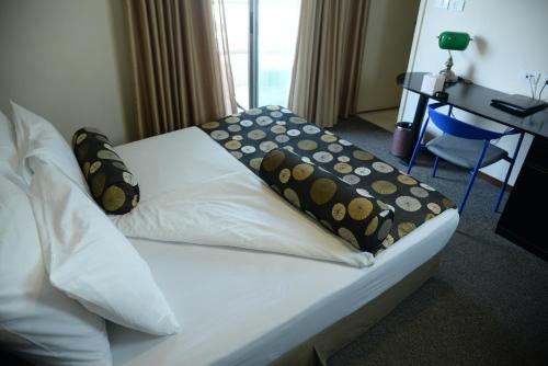 a bed in a hotel room with pillows on it at Royal Court Hotel in Ramallah
