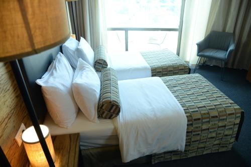 a hotel room with two beds and a window at Royal Court Hotel in Ramallah
