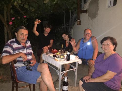 a group of people sitting around a table at Butichi Guest House in Chiatʼura