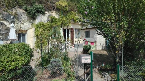 une maison avec une clôture devant elle dans l'établissement Troglo Papillon, à Luynes