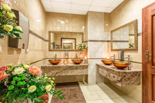 a bathroom with two sinks with bowls in it at Leśna Perła - Restauracja i Pokoje Hotelowe in Rudzinitz