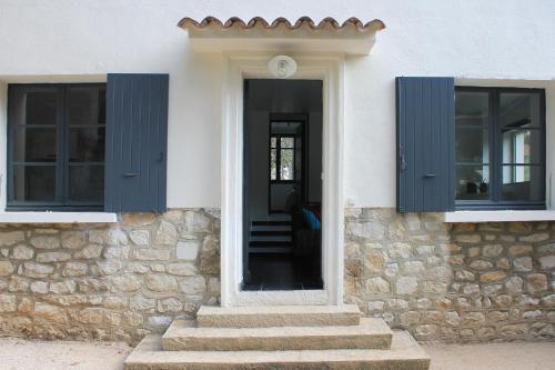 a front door of a house with blue shutters at Home Cassis - Maison Les Calanques - Piscine chauffée à 30c in Cassis