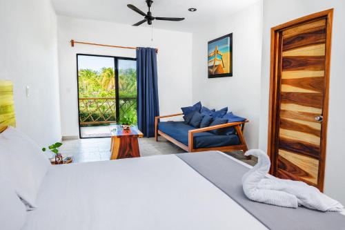 a bedroom with a bed and a chair and a window at Casa Cuyo Hotel in El Cuyo