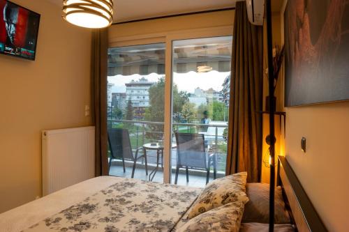 a bedroom with a bed and a view of a balcony at First View Apartment in Katerini