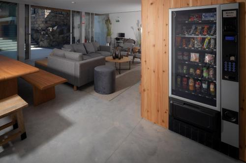 a living room with a couch and a refrigerator at North Shore Hostel in Ribeira Grande