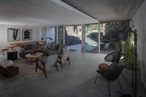 a living room with a couch and a table and chairs at North Shore Hostel in Ribeira Grande