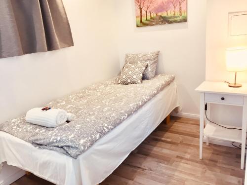 łóżko w pokoju ze stołem i lampką w obiekcie Extraordinary apartment with double shower w mieście Norrahammar