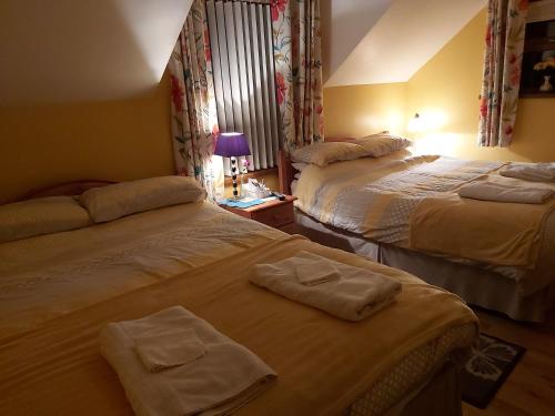 two beds in a hotel room with towels on them at Portrush/ballyhome in Portrush