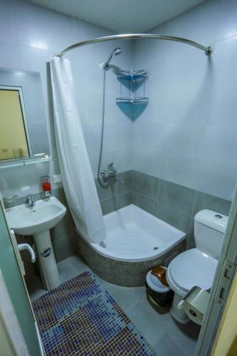 a bathroom with a tub and a toilet and a sink at Rudakiy Guest House in Bukhara