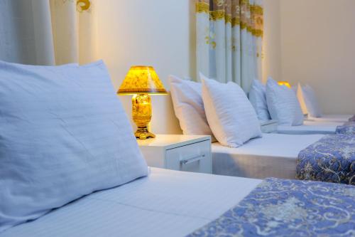 a bedroom with two beds and a lamp on a table at Rudakiy Guest House in Bukhara